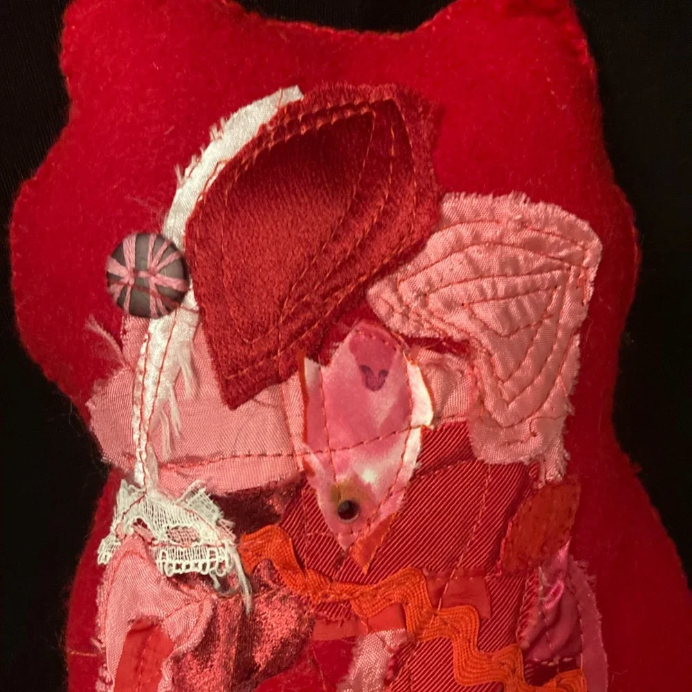 Felted cat pillow with apliqued and stitched designs. Vintage fabric and button.